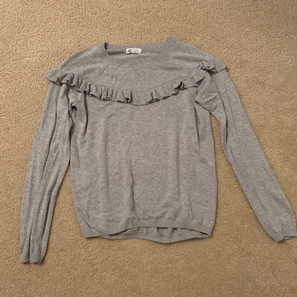 A light weight gray sweater with ruffle